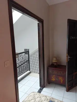a bedroom with a door open to a balcony with a dresser at Riad kech residence al Qarya syahiya Marrakech in Marrakech
