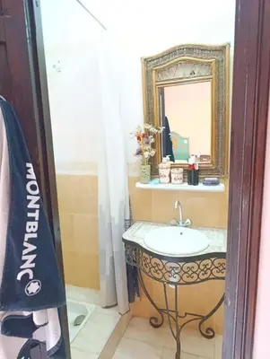 a bathroom with a sink and a mirror at Riad kech residence al Qarya syahiya Marrakech in Marrakech