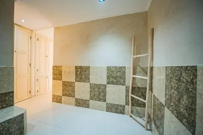 a bathroom with a tiled wall with a ladder at Villa Provence - Pool and Private Garden in Marrakech