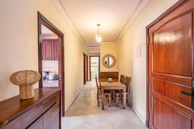 a hallway with a table and a wooden door at Cosy Appartement Rue Loubnane in Marrakech
