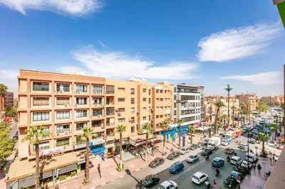 a busy city street with cars parked in front of buildings at Cosy Appartement Rue Loubnane in Marrakech
