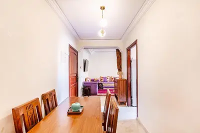 a dining room with a wooden table and chairs at Cosy Appartement Rue Loubnane in Marrakech
