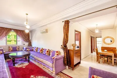 a living room with a purple couch and a table at Cosy Appartement Rue Loubnane in Marrakech