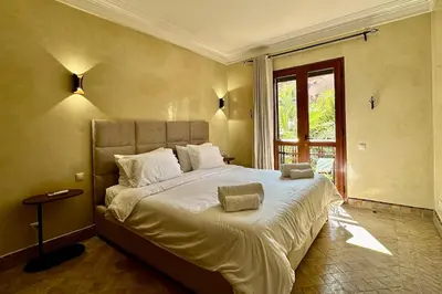 a bedroom with a large bed and a window at Al Qantara with Terrace and Pool in Marrakech