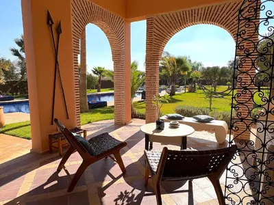 a patio with a table and chairs and a pool at Palais Khemia in Marrakech