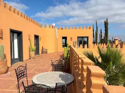 a patio with a table and chairs next to a building at Palais Khemia in Marrakech