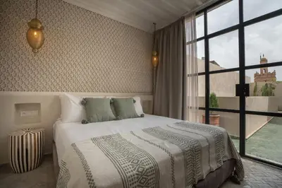 a bedroom with a bed and a large window at Riad Tassili Vert in Marrakech