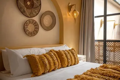 a white bed with gold pillows on top of it at Riad Tassili Vert in Marrakech