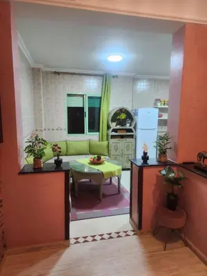 a living room with a green couch and a table at Appartement in Marrakech