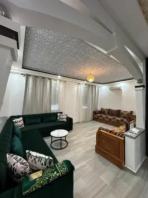 a living room with green couches and a table at KSYI IMMO 6 Marrakech Aéroport in Marrakech