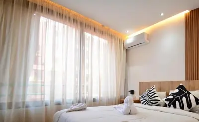 a bedroom with two beds and a large window at Luxurious apartment with private jacuzzi in Marrakech