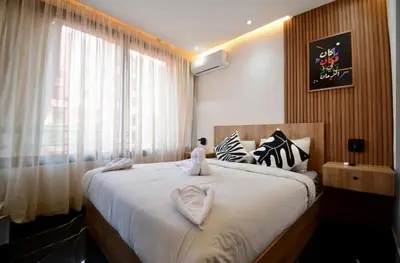 a bedroom with a large bed with a large window at Luxurious apartment with private jacuzzi in Marrakech