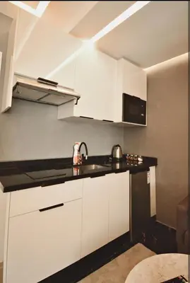 a kitchen with white cabinets and a sink at Luxurious apartment with private jacuzzi in Marrakech