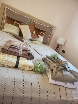a bed with a pile of blankets and pillows at Riad Duplex de charme 2 chambres in Marrakech