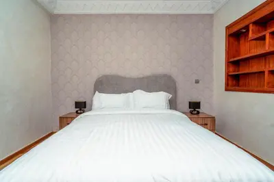 a bedroom with a large white bed with two night stands at Yaza appartement in Marrakech