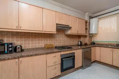 a kitchen with wooden cabinets and a stove top oven at Yaza appartement in Marrakech