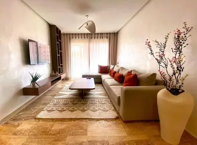 a living room with a couch and a vase with flowers at Élégance & confort au centre ville de Marrakech in Marrakech