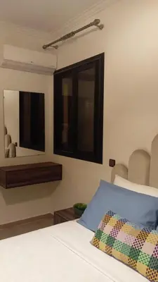 a bedroom with a bed and a mirror at Charmant appartement au coeur de Guéliz à côté de train in Marrakech
