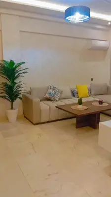 a living room with a couch and a table at Charmant appartement au coeur de Guéliz à côté de train in Marrakech