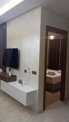 a living room with a television and a bed at Charmant appartement au coeur de Guéliz à côté de train in Marrakech