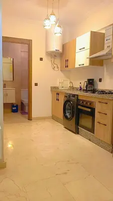 a kitchen with a washing machine in the middle at Charmant appartement au coeur de Guéliz à côté de train in Marrakech