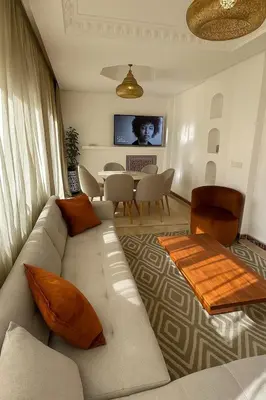 a living room with a couch and a table at Premium Village, appartement cosy in Marrakech