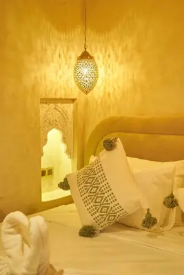 a bedroom with a bed with a pillow and a mirror at Taj Riad Zitoune in Marrakech