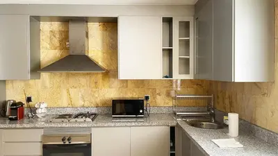 a kitchen with white cabinets and a sink and a microwave at Chic Plaza City Center in Marrakech