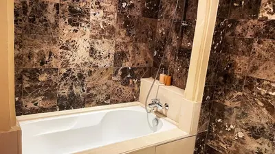 a bathroom with a bath tub with a sink at Chic Plaza City Center in Marrakech