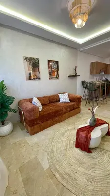 a living room with a brown couch and a rug at Cozy apartment with pool Downtown Marrakech in Marrakech