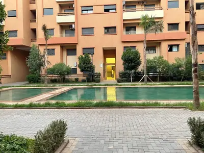 a building with a swimming pool in front of a building at Cozy apartment with pool Downtown Marrakech in Marrakech