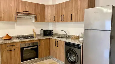 a kitchen with a refrigerator and a dishwasher at Cozy apartment with pool Downtown Marrakech in Marrakech