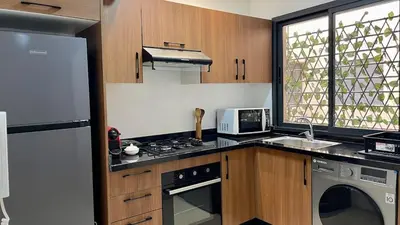 a kitchen with a refrigerator and a stove top oven at Burj Malak Comfort and Pool in Marrakech