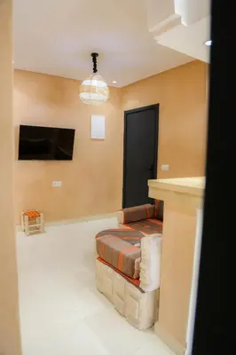 a living room with a couch and a tv at Stylish YSL Street 2-BDR, parking, hi speed wifi in Marrakech