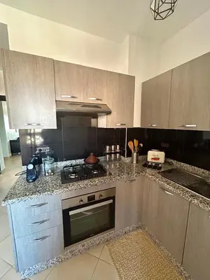 a kitchen with a counter with a stove top oven at Appartement moderne 2 chambres proche Gueliz in Marrakech