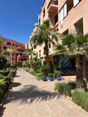 a street with palm trees in front of a building at Appartement moderne 2 chambres proche Gueliz in Marrakech