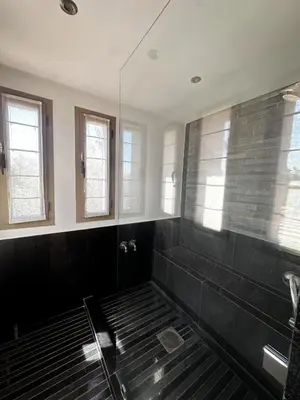 a bathroom with a shower with black tile and windows at Luxury Villa 4 Bedrooms with Big Pool 5km from Medina in Marrakech