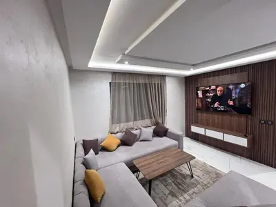 a living room with a couch and a tv at Appartement chic & elegant in Marrakech