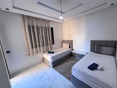 a bedroom with two beds and a tub and a window at Appartement chic & elegant in Marrakech