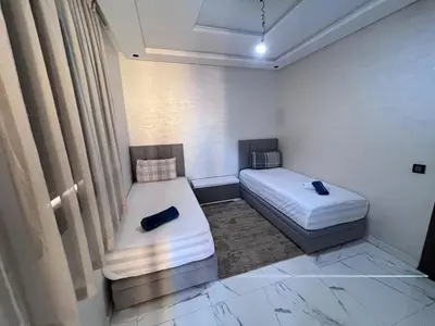 two beds in a small room with curtains at Appartement chic & elegant in Marrakech
