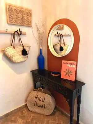 a table with a mirror and a basket on a wall at Riad Awel Oasis Privée au coeur de la Medina in Marrakech