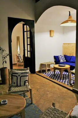 a living room with a blue couch and a table at Riad Awel Oasis Privée au coeur de la Medina in Marrakech