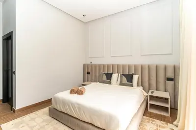 a bedroom with a large bed with white walls at Villa NAYA in Marrakech
