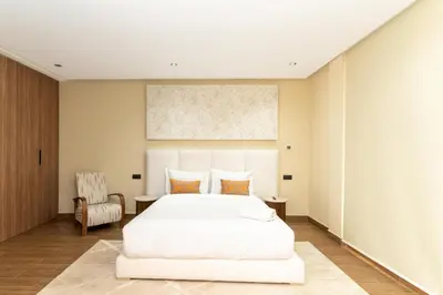 a bedroom with a large white bed and a chair at Villa NAYA in Marrakech