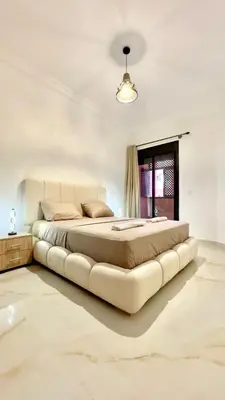 a large bed in a white bedroom with a couch at Marrakech Luxury Apartment with Pool & gym in Marrakech