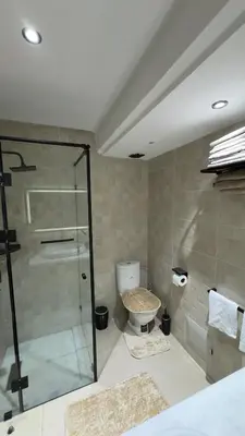 a bathroom with a glass shower and a toilet at Marrakech Luxury Apartment with Pool & gym in Marrakech