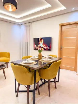 a dining room with a table and yellow chairs at Central Apartment in Gueliz Steps from Carré Eden in Marrakech
