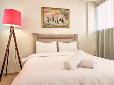 a bedroom with a white bed with a red lamp at Central Apartment in Gueliz Steps from Carré Eden in Marrakech