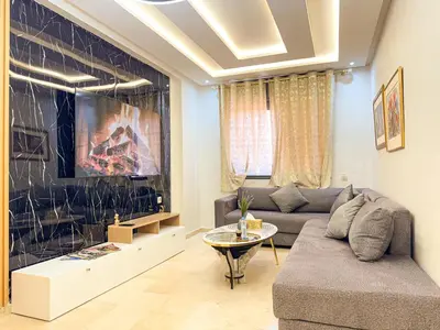 a living room with a couch and a tv at Central Apartment in Gueliz Steps from Carré Eden in Marrakech