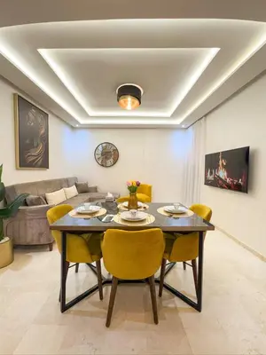 a dining room with a table and yellow chairs at Central Apartment in Gueliz Steps from Carré Eden in Marrakech